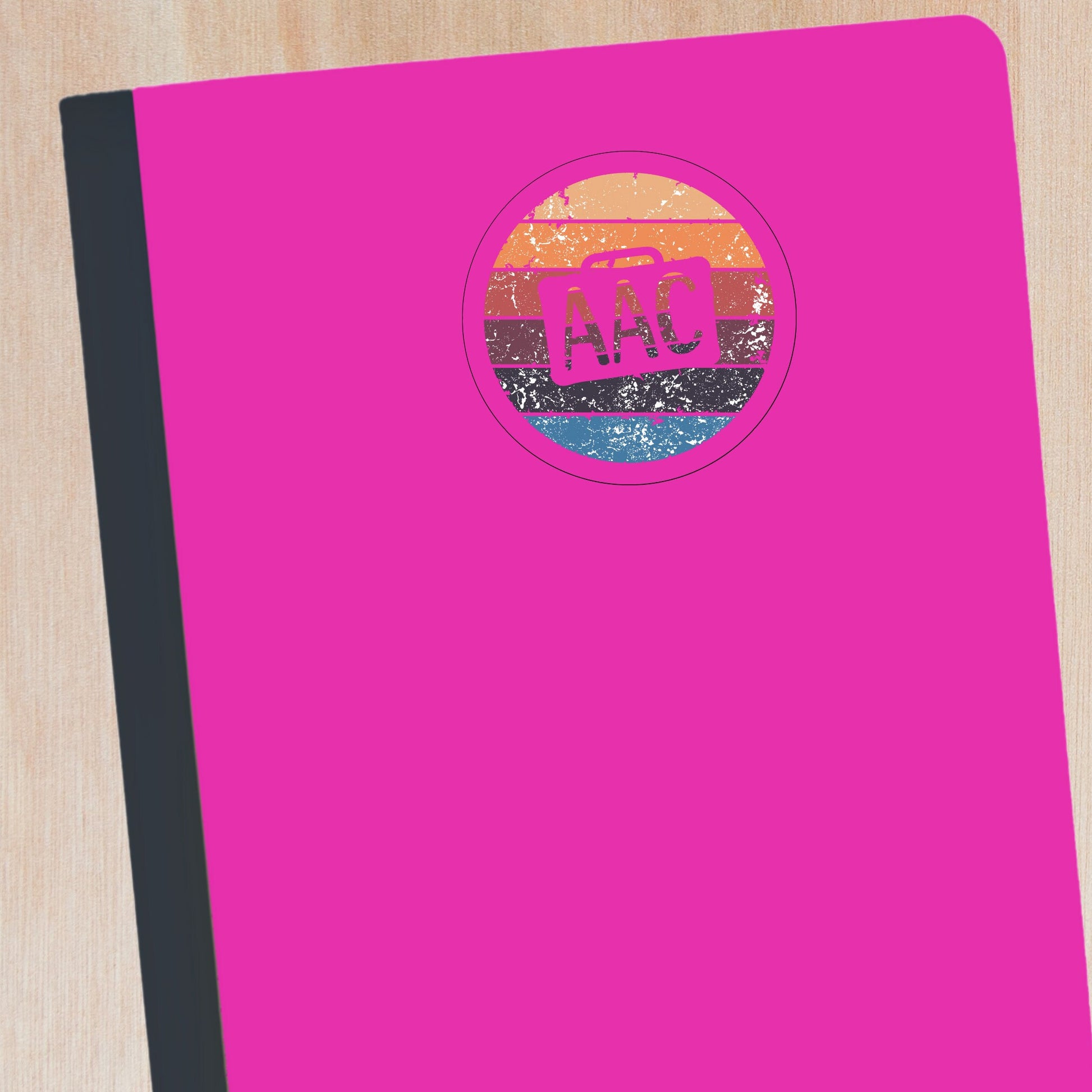 Clear circle AAC speaker with retro colors.  There is an AAC device cutout with AAC written inside.  The AAC decal is on a notebook.